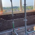 Metselwerk in aanbouw met uitzicht op stad.